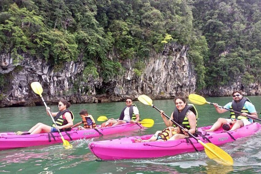 People kayaking on a river with rocky cliffs in the background. 4