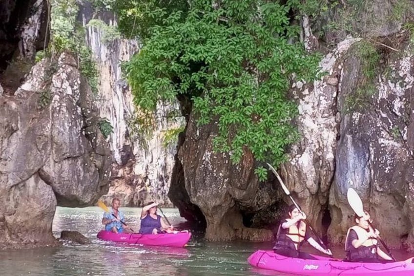 People kayaking in a rocky canyon with waterfalls and greenery. 2