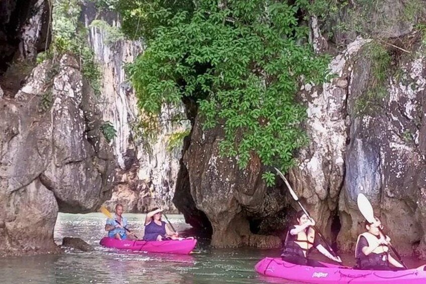 People kayaking in a rocky canyon with a waterfall in the background. 2