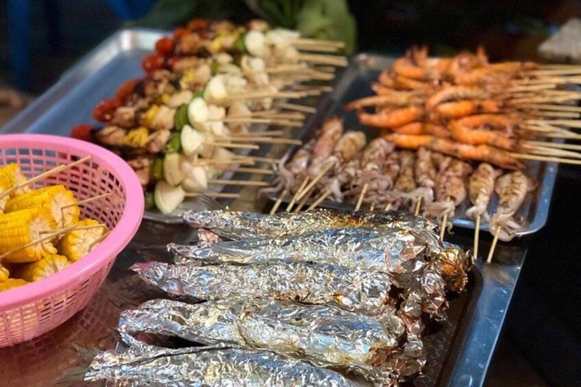 Variedad de mariscos a la parrilla, incluyendo pescado, camarones y vegetales ensartados. 5