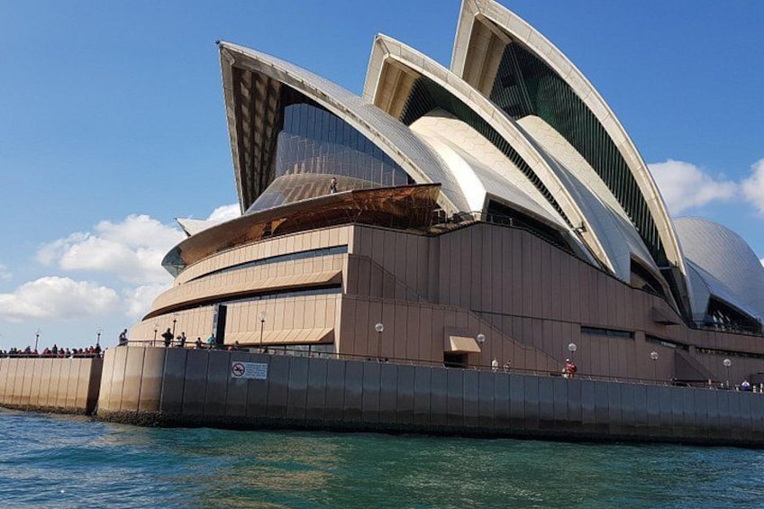 A large, modern opera house with a distinctive sail-like roof, situated by the water. 5