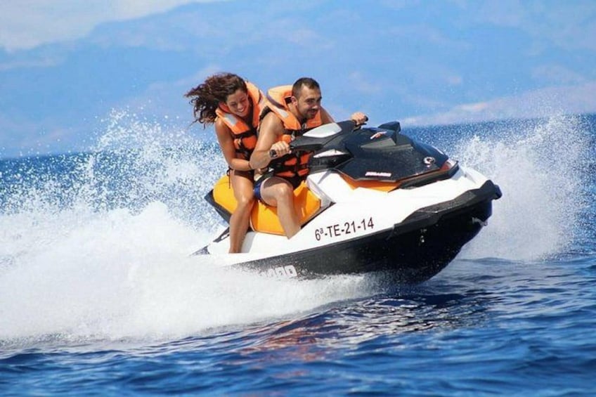 A jet ski with two people wearing life jackets. 2