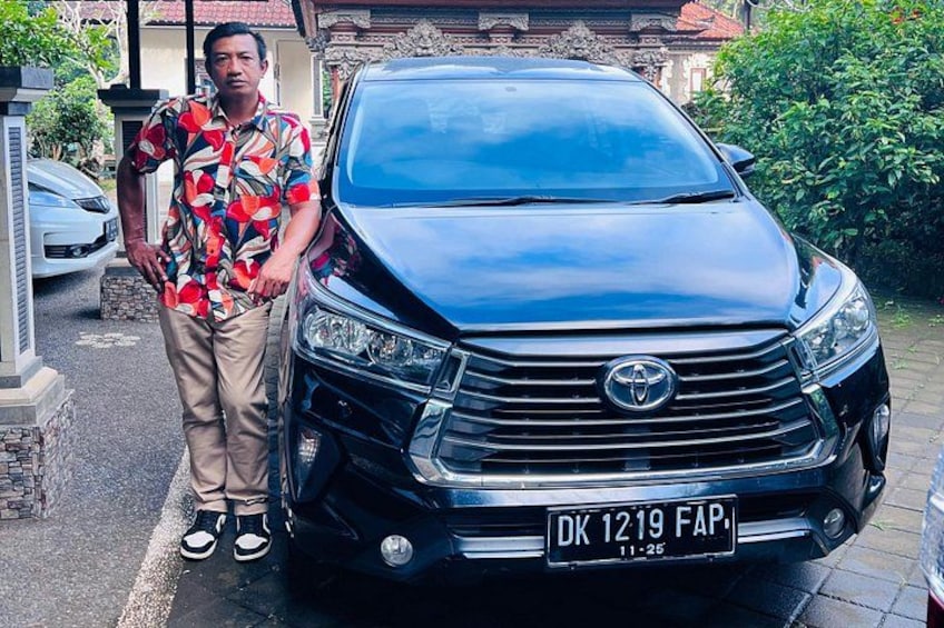 Een man staat naast een zwarte Toyota met een kenteken. 3