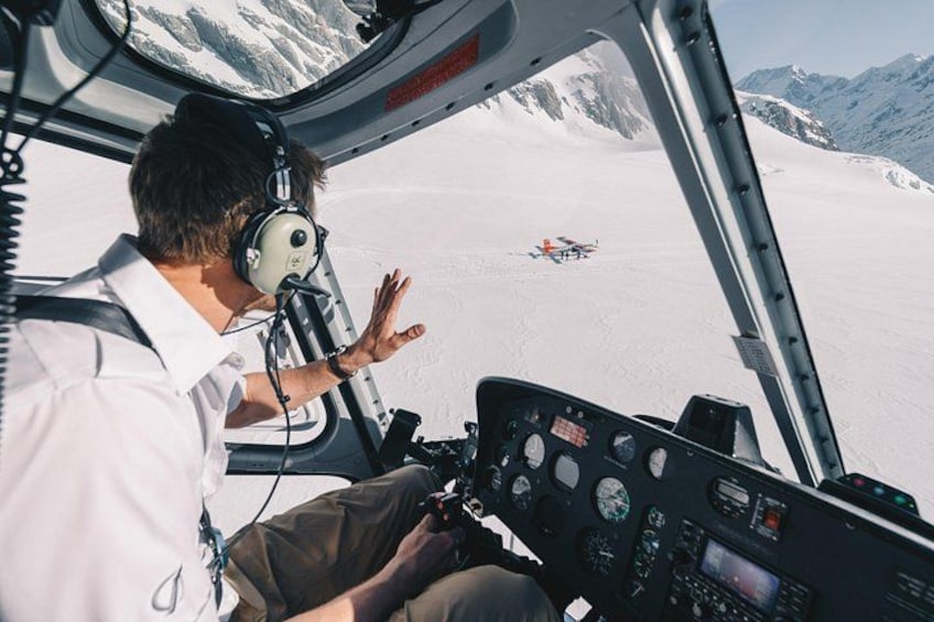 Una persona en la cabina de un helicóptero, con un paisaje nevado y montañas al fondo. 2