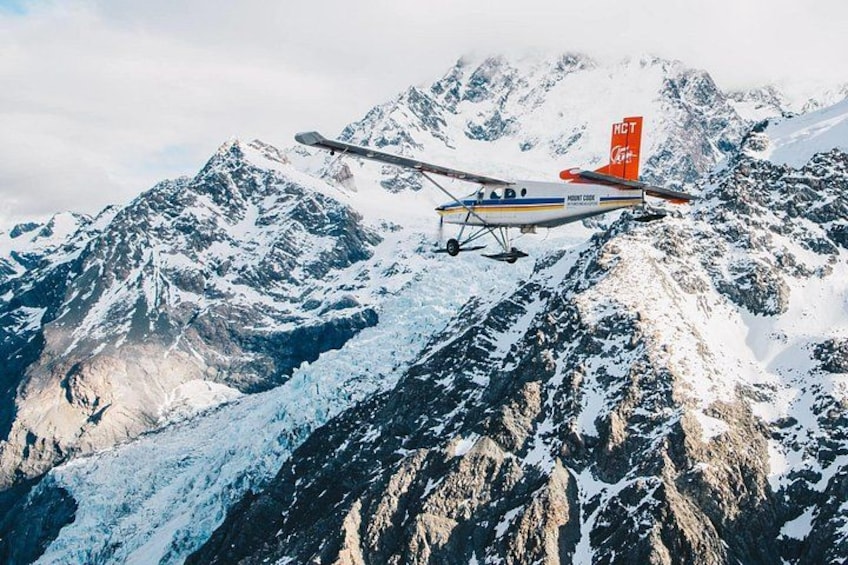 Un pequeño avión volando sobre un paisaje montañoso. 3