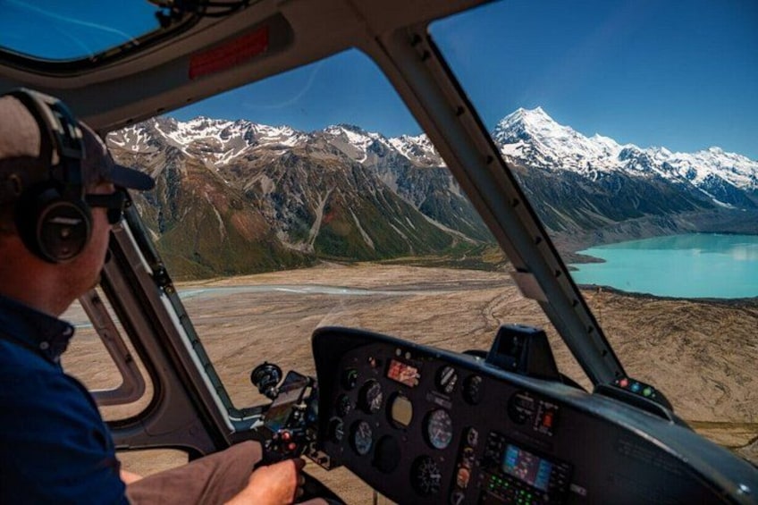 Cabina de helicóptero con un paisaje montañoso y un lago al fondo. 2