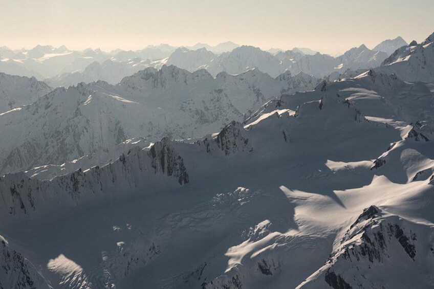 A snow-covered mountain range with rugged peaks and valleys. 3