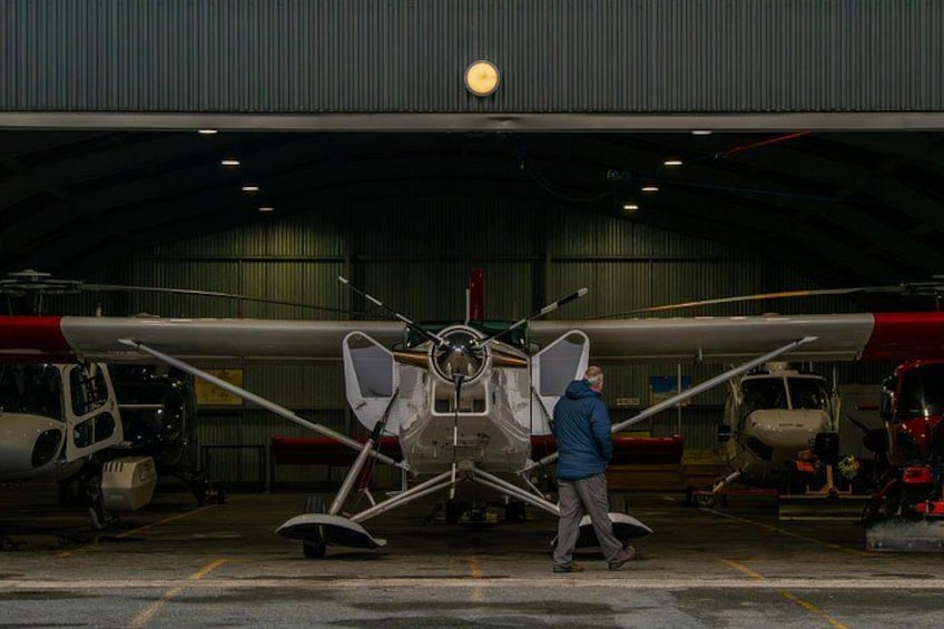 A hangar with a large aircraft parked inside. 2