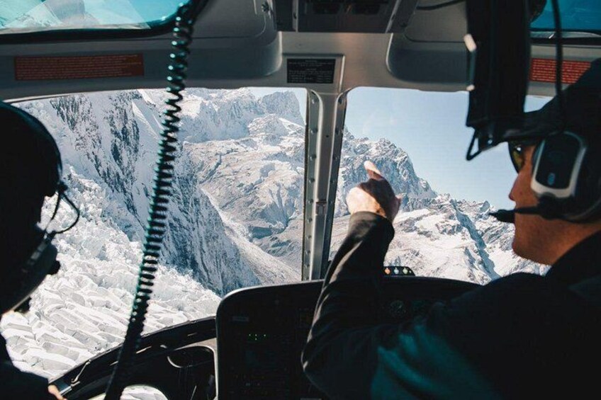 A helicopter cockpit with a mountainous landscape outside. 2