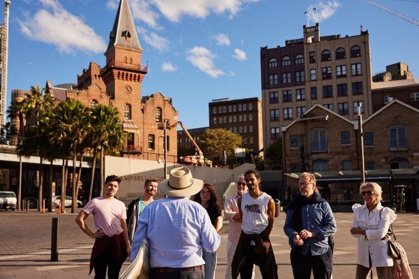 A group of people walking on a city street with historic buildings in the background. 4