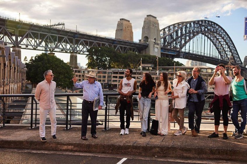 A group of people standing on a bridge with the Sydney Harbour Bridge in the background. 3