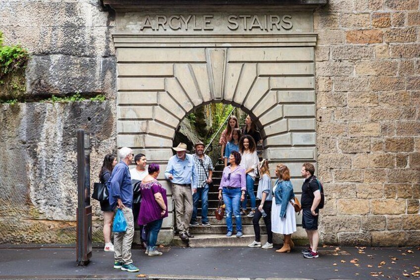 A group of people standing in front of a stone staircase labeled 'Argyle Stairs' with a metal handrail on the left. 5