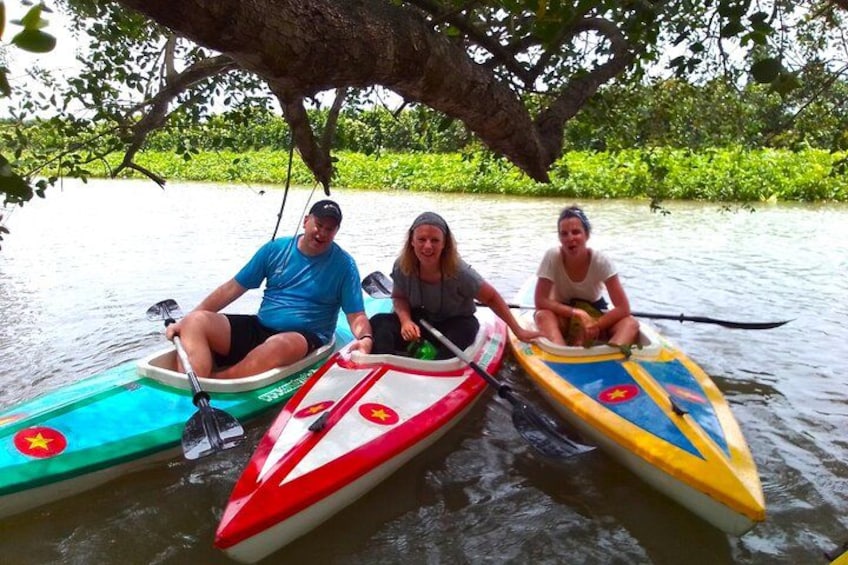 Three people in canoes on a calm river. 5