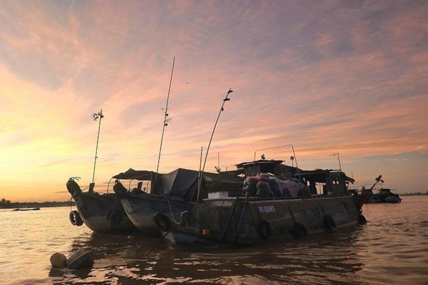 A boat docked at sunset with fishing rods on deck. 4