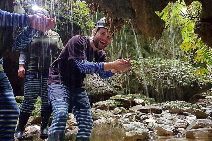 A person in a striped outfit near a rocky stream with water flowing over rocks. 3