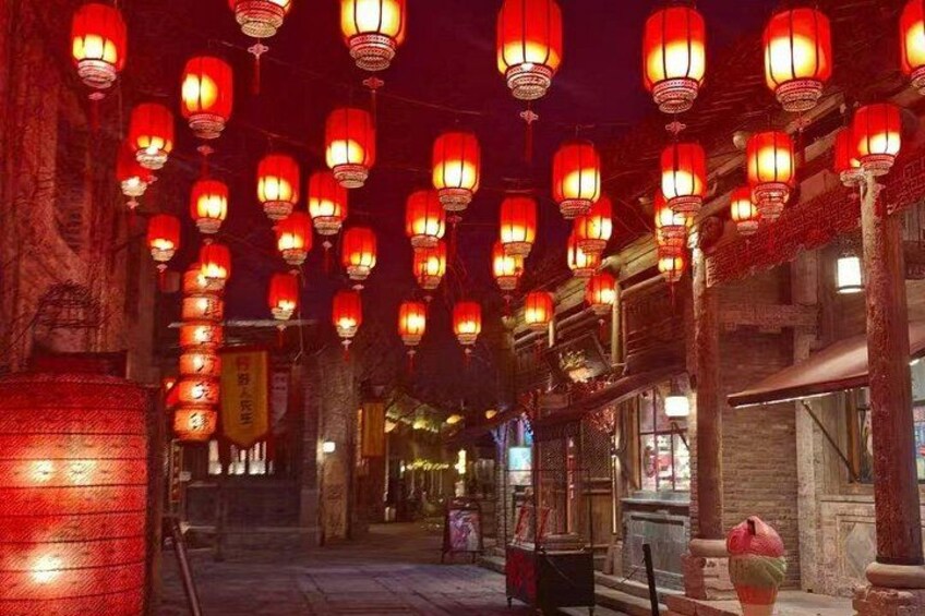 A street at night with red lanterns hanging overhead. 2