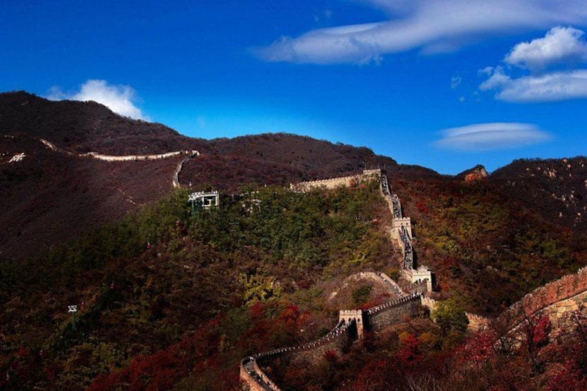 Un paysage montagneux avec une route sinueuse et une grande structure murale. 2