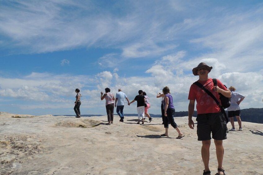 A group of people walking on a rocky terrain with a clear sky. 4