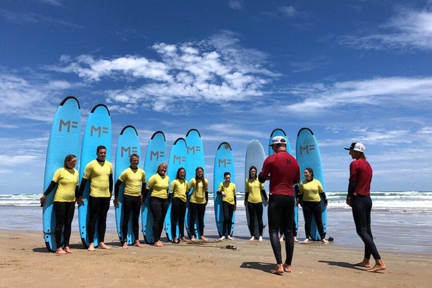 Een groep mensen op het strand met surfplanken. 4