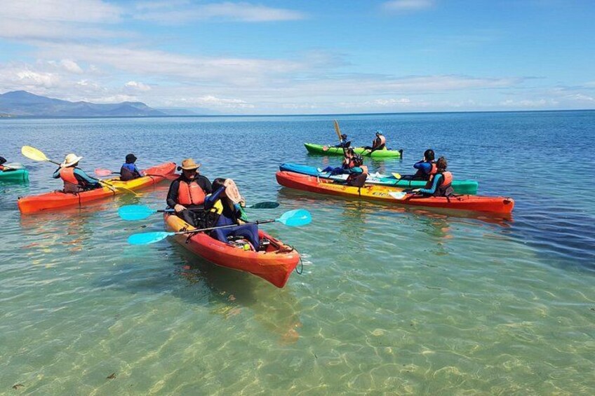 Personas haciendo kayak en un lago tranquilo con montañas al fondo. 3