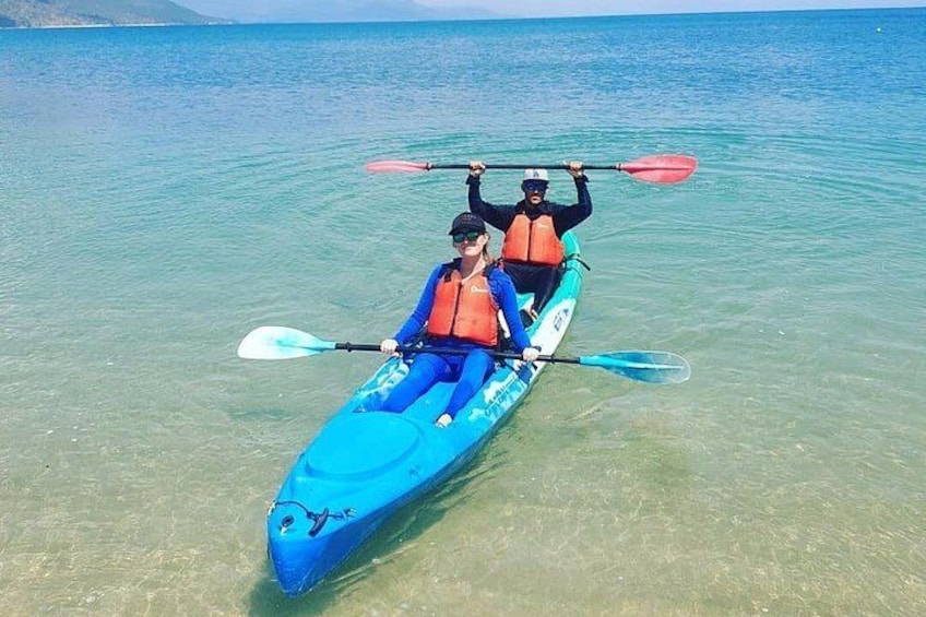 Dos personas hacen kayak en un mar azul y despejado. 2