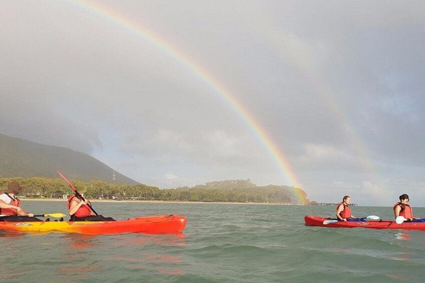 Kayakistas en aguas tranquilas, con un arcoíris al fondo. 4