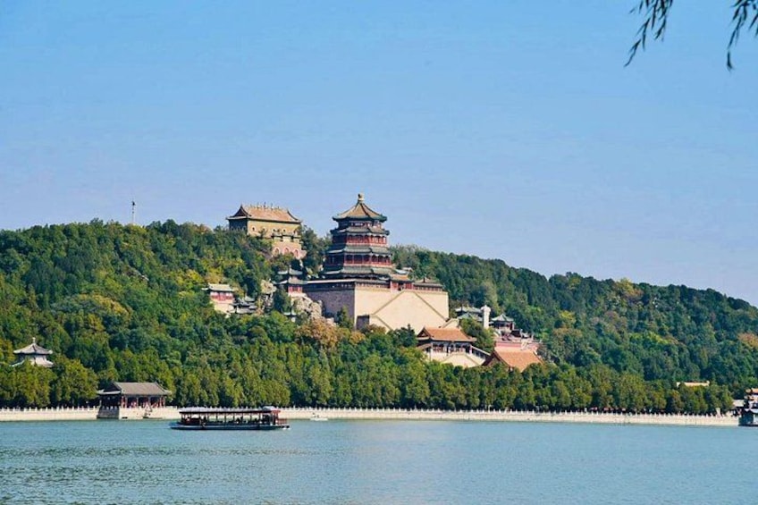 A traditional multi-tiered pagoda on a hill, a body of water in the foreground, and a boat. 4