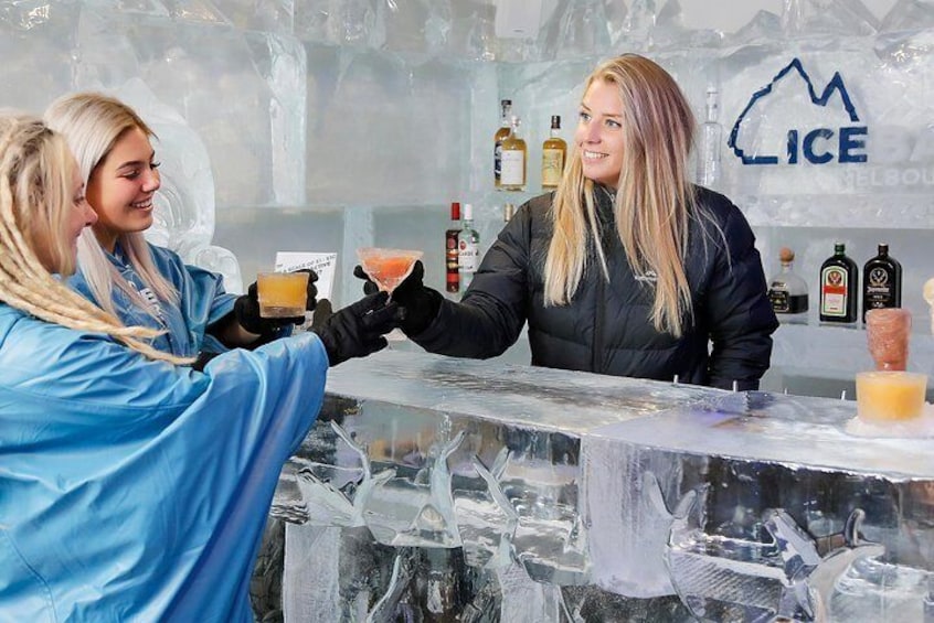 Un bar con una barra de cristal y esculturas de hielo al fondo. 1