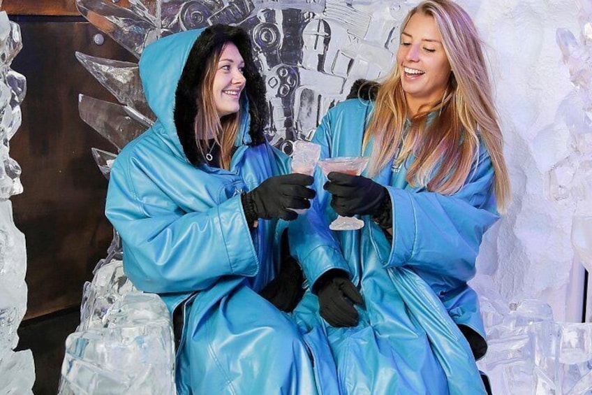 Dos personas con impermeables azules sentadas sobre esculturas de hielo. 3