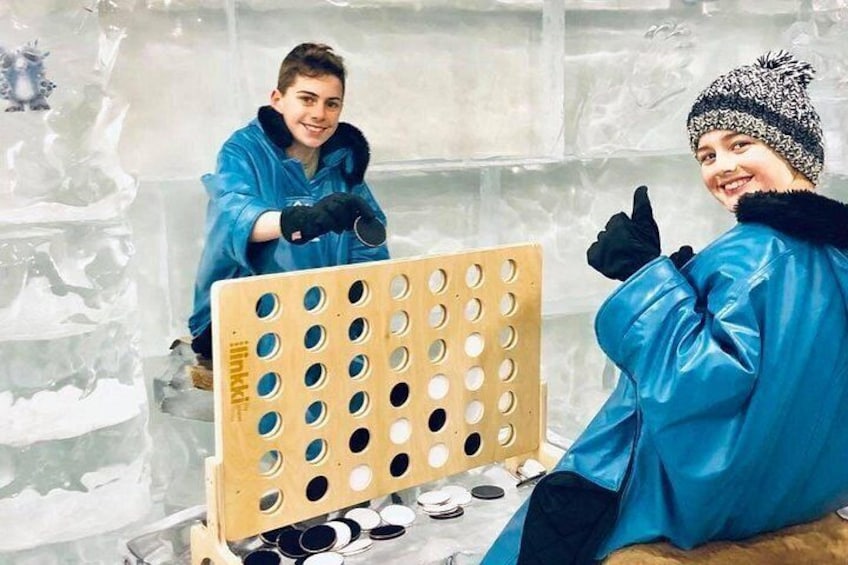 Dos personas con chaquetas y gorros azules trabajando con una estructura de madera en un entorno helado. 2