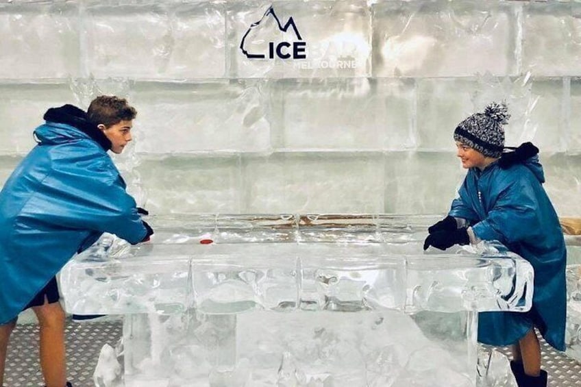 Dos personas trabajando en una escultura de hielo en un taller. 5