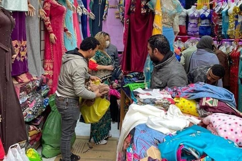 A market with colorful fabrics and clothing items on display. 5