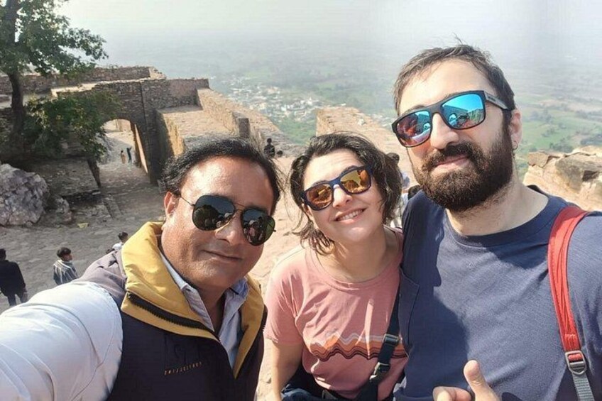 Tres personas tomándose un selfie con un sitio histórico de fondo. 1