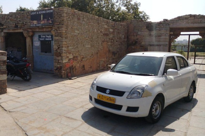 Un coche blanco estacionado frente a un edificio con un cartel que dice 'Light & Sound Show'. 4