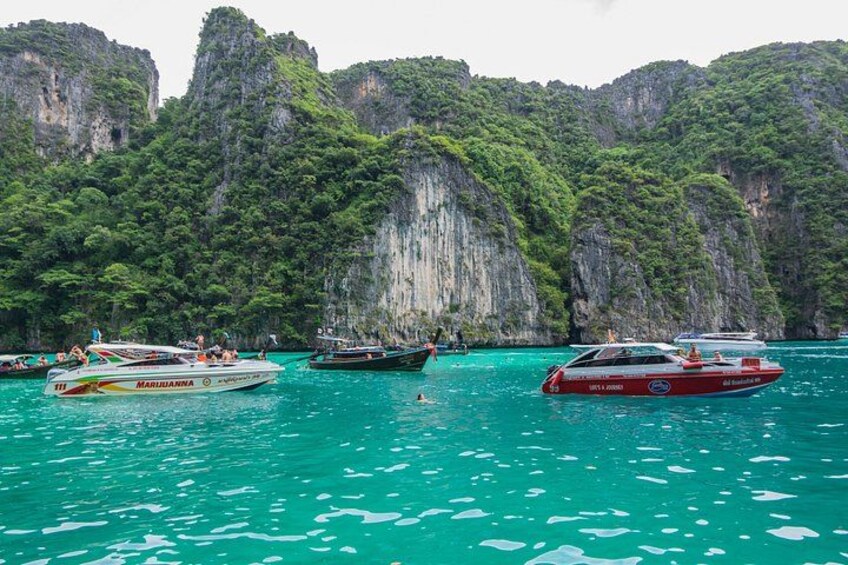 Speedboats gather around Phi Phi Island for travelers to snorkel in the clear blue waters. 3