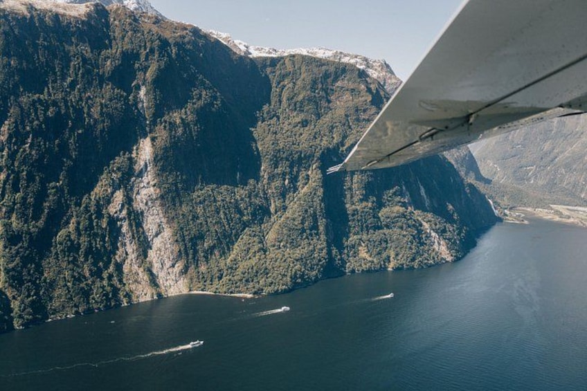 Paisaje montañoso con una masa de agua, una ala de avión y una pequeña isla. 2
