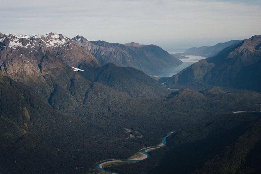 Un paisaje montañoso con un río serpenteando a través de él. 1