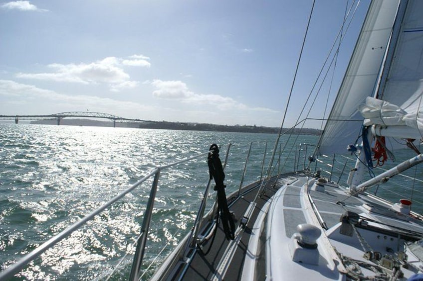 A sailboat on water with a bridge in the background. 5