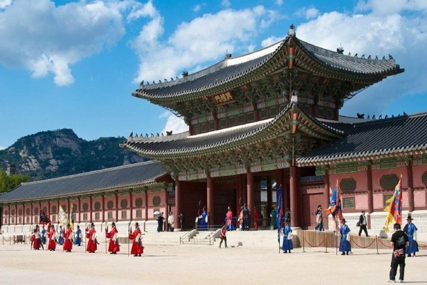 A traditional Korean palace with a multi-tiered roof and red walls. 1