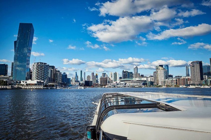 A city skyline with modern buildings, a body of water, and a boat in the foreground. 1