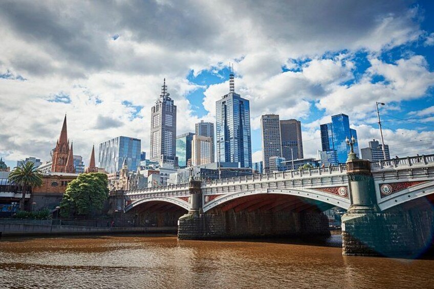 Une vue sur les toits d’une ville, avec des gratte-ciel modernes, un pont historique et une rivière. 2