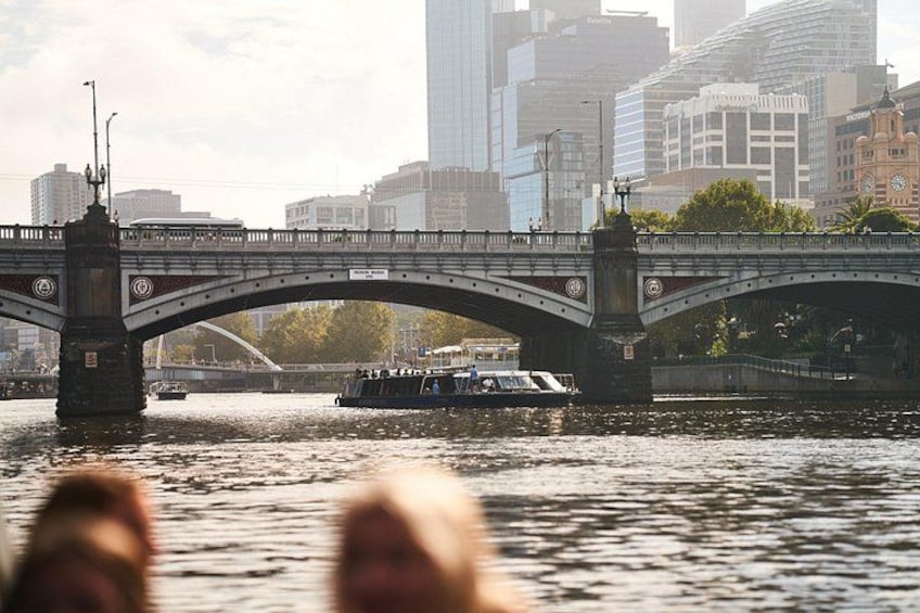 Un pont enjambant une rivière, avec un bateau sur l’eau, le tout entouré d’immeubles de la ville. 4