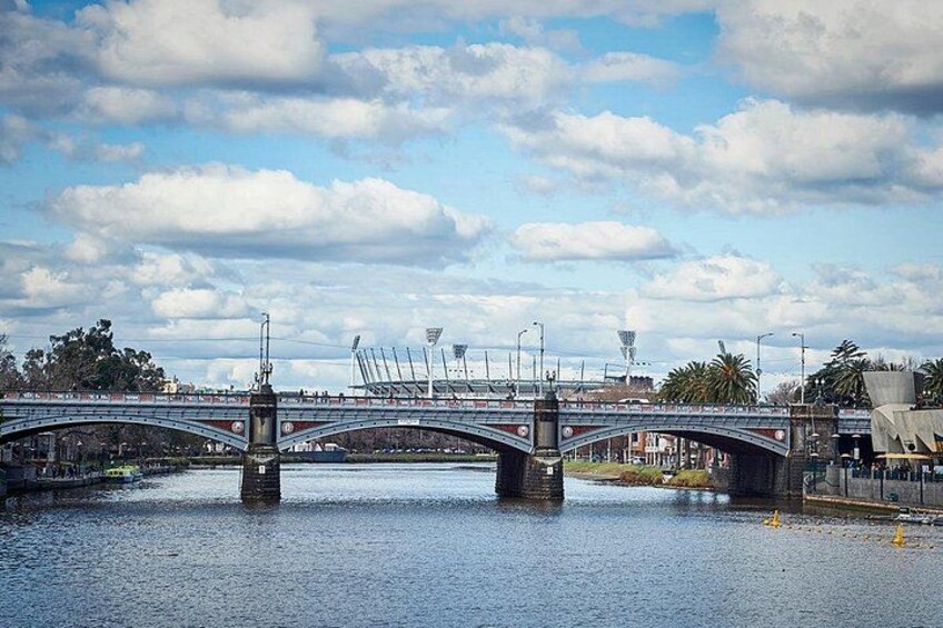 Un pont enjambant une étendue d’eau, avec un stade en arrière-plan. 3