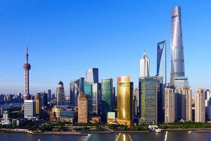 Un horizonte urbano con rascacielos modernos, una torre destacada y un río en primer plano. 3