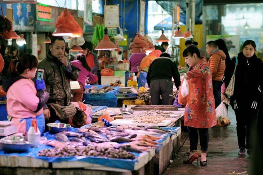 Ein belebter Markt voller Menschen, die einkaufen, und Händler, die Waren anbieten. 2
