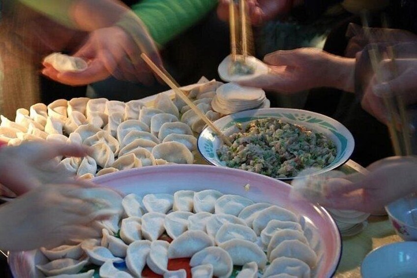 Une table avec des raviolis et un plat de nourriture, probablement dans le cadre d’un repas partagé. 1