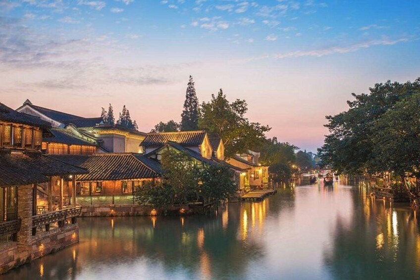 A riverside village with traditional architecture, calm water, and a clear sky. 2