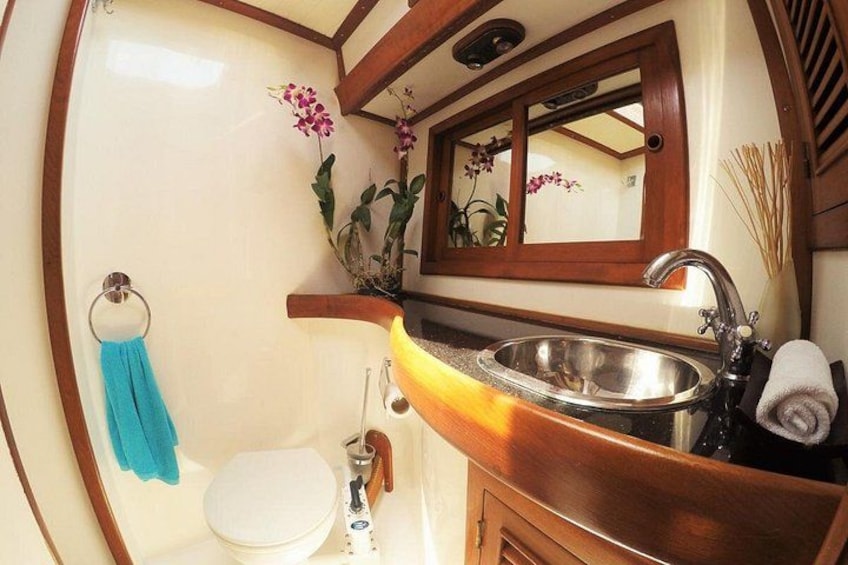 Un baño con inodoro blanco, lavamanos y espejo. 3