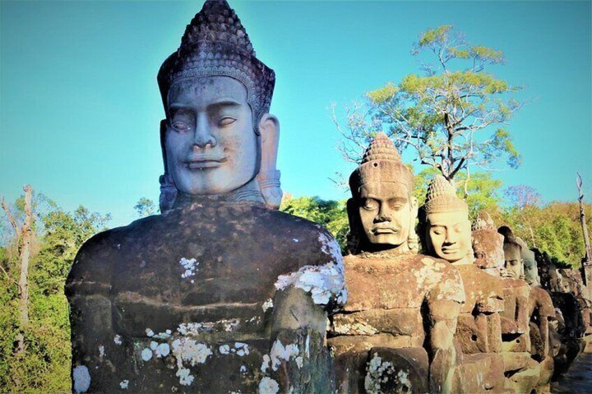 Una gran estatua de Buda de piedra con estatuas más pequeñas al fondo. 3
