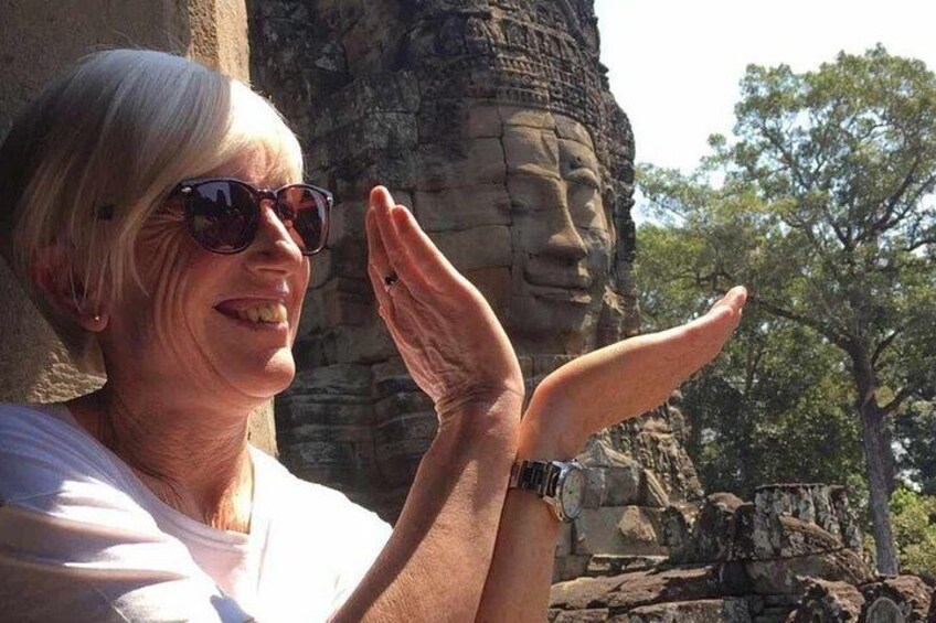 A person standing in front of a large stone structure with a carved face. 4